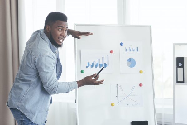 Confident top manager presenting company development plan to colleagues Confident top manager presenting company development plan to colleagues